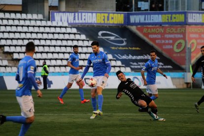 Eneko Satrústegui intenta controlar la pilota davant un jugador de l’Ebro que perd l’equilibri.