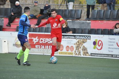 El capità de l’Alpicat, Xavi Gomà, condueix l’esfèric davant l’oposició d’un jugador de l’Igualada.