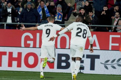 Benzema, perseguit per Vinicius, celebra un dels dos gols que va marcar ahir a Girona.