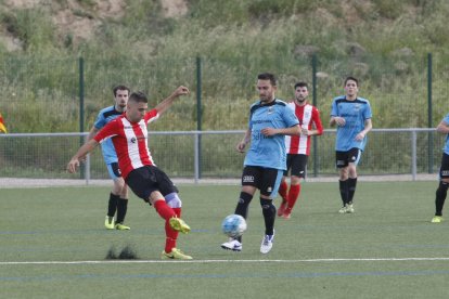 Un jugador visitant remata davant la pressió d’un local.