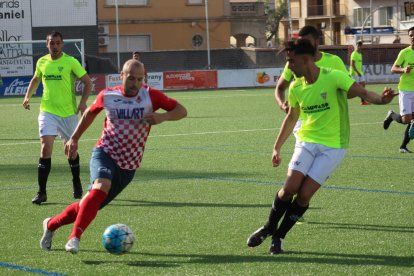 Adrià, con el balón controlado, encara a un jugador del Viladecans, con otros dos rivales atentos al balón.