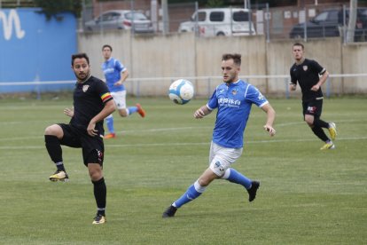 Un jugador de l’Andorra passa la pilota davant la pressió d’un jugador del Lleida B.