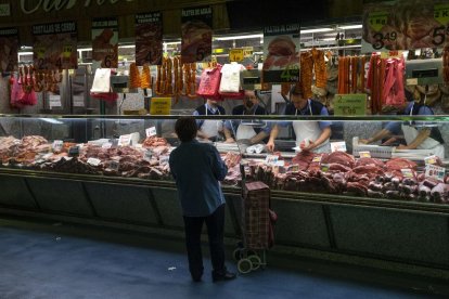 Un carnicero, atendiendo a una cliente. 