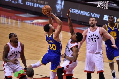 Stephen Curry intenta anotar davant de Lowry i Marc Gasol.