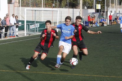 Un jugador del Lleida intenta avanzar ante la oposición de dos futbolistas del Reus.