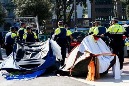 Agents de la Guàrdia Urbana retirant les tendes del campament de la plaça Catalunya, ahir.