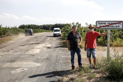 Dos vecinos ante el indicador de fin de término. Los baches pertenecen a Lleida.