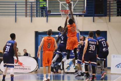 Ablaye Mbaye intenta palmear con claridad un balón con Chuku presionando.