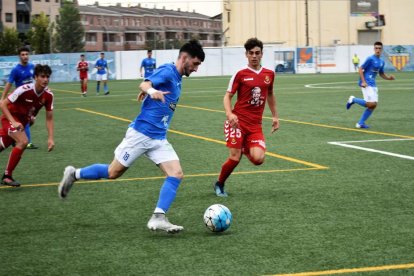 Un jugador del Alcarràs controla el balón ante un rival en una acción del partido.