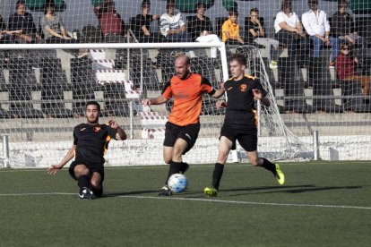 Un jugador del Les intenta deshacerse de dos rivales locales en una jugada del encuentro.