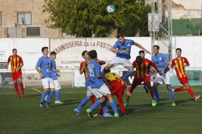 Un jugador del Alcarràs salta por encima de los rivales para rematar un balón en una acción del partido.