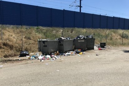 Imagen de los contenedores y la basura junto a las vías del tren.