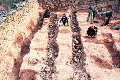 Vecinos y familiares de soldados, en la fosa del viejo cementerio.