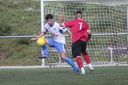 Un jugador del Mollerussa controla l’esfèric davant la pressió d’un jugador del Santboià.