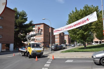 Un operario instala la pancarta de las fiestas de la Mariola.