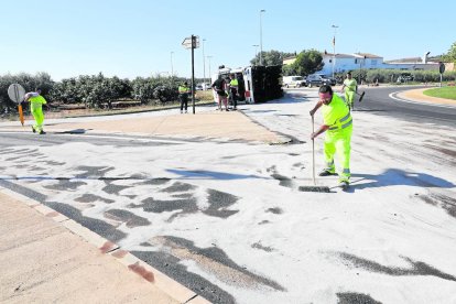 Operarios tiraron arena sobre la carretera para que absorbiera el gasoil de la cuba, volcada en el fondo de la imagen. 