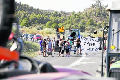 Alrededor de 100 afectados cortaron ayer la carretera C-12 en Flix, con pancartas y tractores durante una hora y media. 