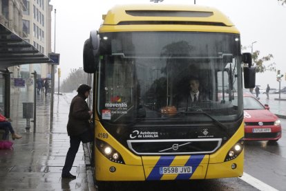 Una usuària puja a un autobús a la parada davant de la Paeria.