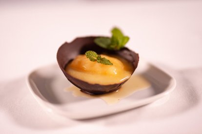 Presentació del mousse de nectarina un cop afegit el sorbet i decorat amb una fulla de menta.