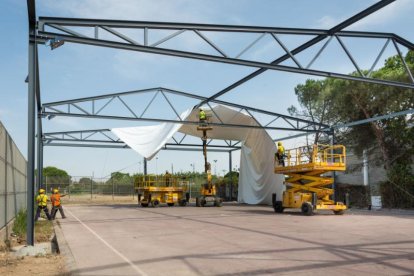 Moment de la col·locació de la carpa a la pista poliesportiva.