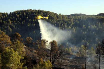 Un helicòpter descarregant aigua sobre l’incendi.