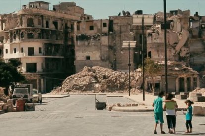 Un grup de nens davant d’un edifici en ruïnes, a la ciutat d’Alep.