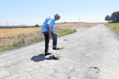 Un vecino de la Caparrella cubriendo baches con barro en el Camí de les Creus del Setó.