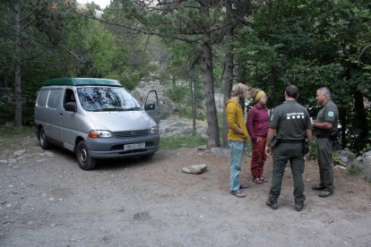 Agents Rurals informen de la normativa a una parella de visitants del Parc Nacional d'Aigüestortes.