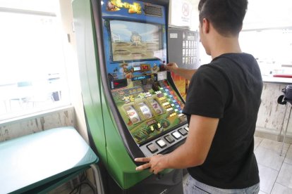 Un usuari jugant a una màquina escurabutxaques en un bar de Lleida.