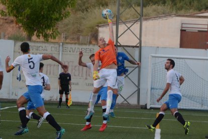 El portero del Borges despeja un balón en su área pese al intento de remate de un jugador local.