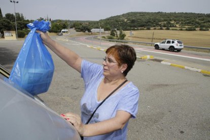 Una vecina deposita la basura en un contenedor. 