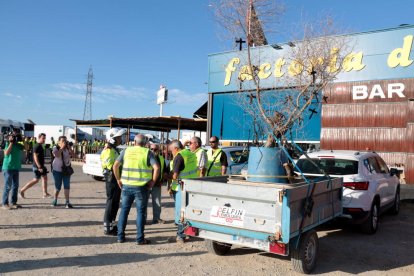 La marcha lenta la cierra una vehículo con un remolque que transporta un olivo quemado en el incendio con varias cruces negras colgadas.