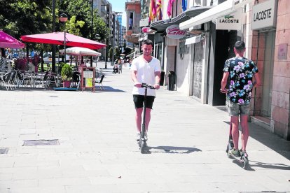 Dos usuaris de patinets elèctrics circulant per l’avinguda Blondel.