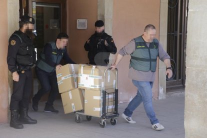 Agents de la Guàrdia Civil s'emporten de l'ajuntament d'Almacelles caixes amb documents.