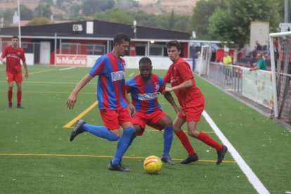 Dos jugadors del Vilanova de la Barca protegeixen l’esfèric davant la pressió d’un jugador de l’Alpicat B.