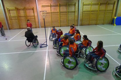 Nens d’un col·legi de Lleida practicant bàsquet en cadira de rodes.