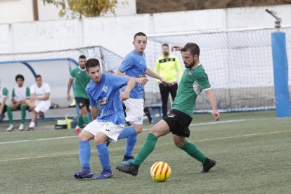 Un jugador del Alcarràs trata de desplazar el balón acosado por otro del Ascó.