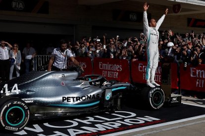 Lewis Hamilton celebra su sexto Mundial de Fórmula Uno subido en una rueda de su monoplaza.