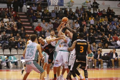 Miki Feliu, Mbaye i Ogungbemi-Jackson lluiten per una pilota contra diversos jugadors de l’Osca, en una acció del partit d’ahir.