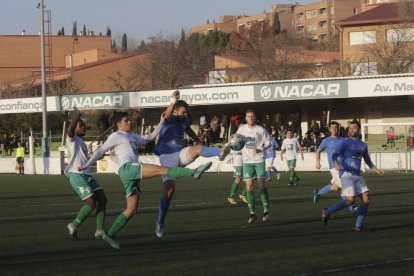 Un jugador de l’Alcarràs remata davant d’un defensa del Balàfia durant el partit.