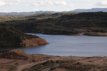 Operarios trabajaban ayer en la reposición de caminos en el entorno del pantano, al fondo.