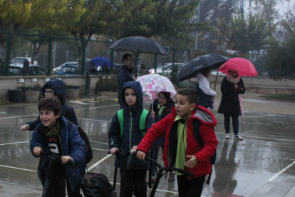 Algunos de los alumnos del colegio llegando en patinete.