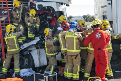 Els serveis d'emergència rescaten el conductor atrapat al seu vehicle després del xoc.