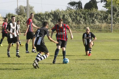 Un jugador del Tàrrega controla la pilota davant d’un futbolista rival.