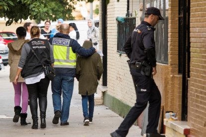 La policia, amb el nen que va trobar el cos de la seua mare, ahir.