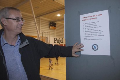 Santi Vergé mostra un dels cartells que hi ha penjats al pavelló on juga el CN Tàrrega.