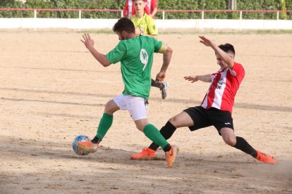 Un jugador local intenta prendre la pilota a un de visitant.