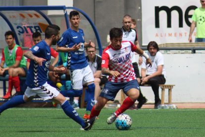 Genís porta una pilota davant l’oposició de dos jugadors rivals.