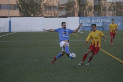 Un jugador del Alcarràs golpea el balón ante la presión rival.