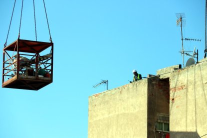 Els operaris que treballen en la demolició, ahir al terrat del bloc afectat.